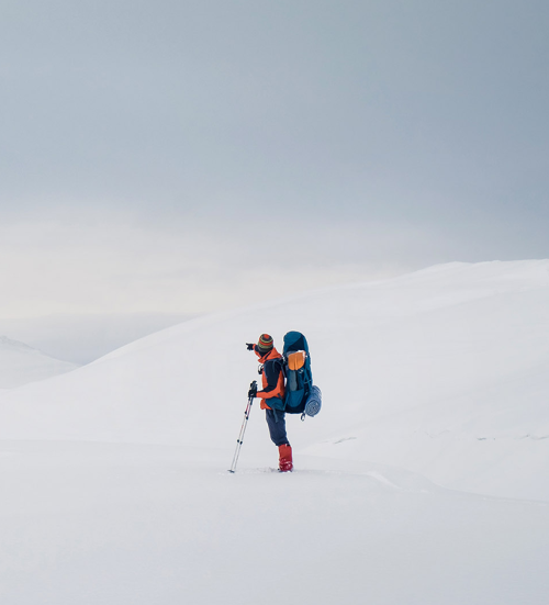 man hiking on snow hills trekking