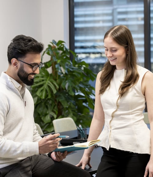 two colleagues takling reviewing notes in meeting room