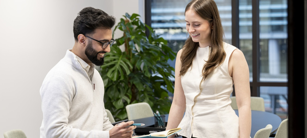 two colleagues takling reviewing notes in meeting room