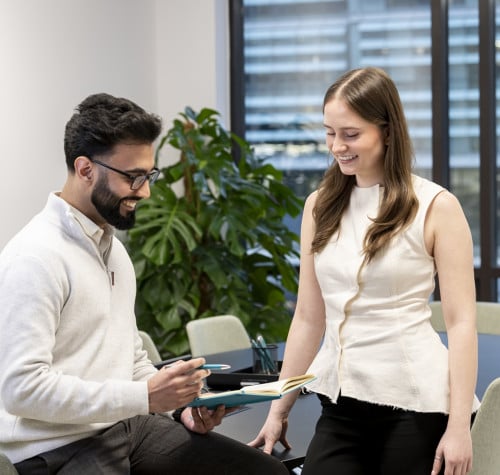two colleagues takling reviewing notes in meeting room