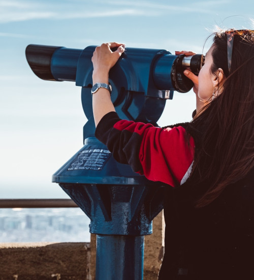 woman looking city barcelona tibidabo using binoculars