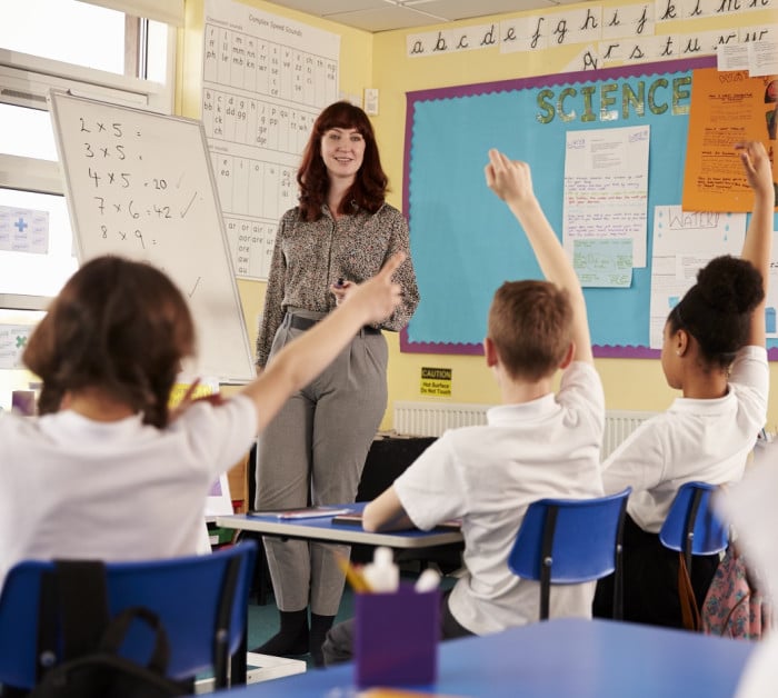 kids raising hands primary school class