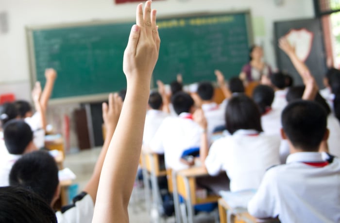 kids raising hands primary school class