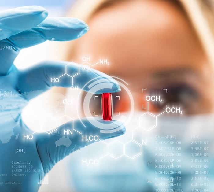 female scientist holding red pill