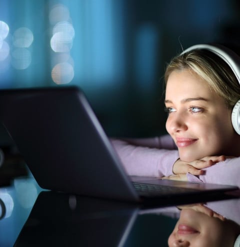 satisfied teen wearing headphones watching media v2