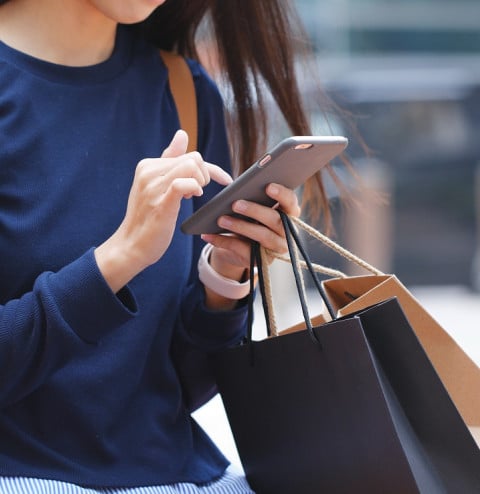 woman look mobile phone holding shopping