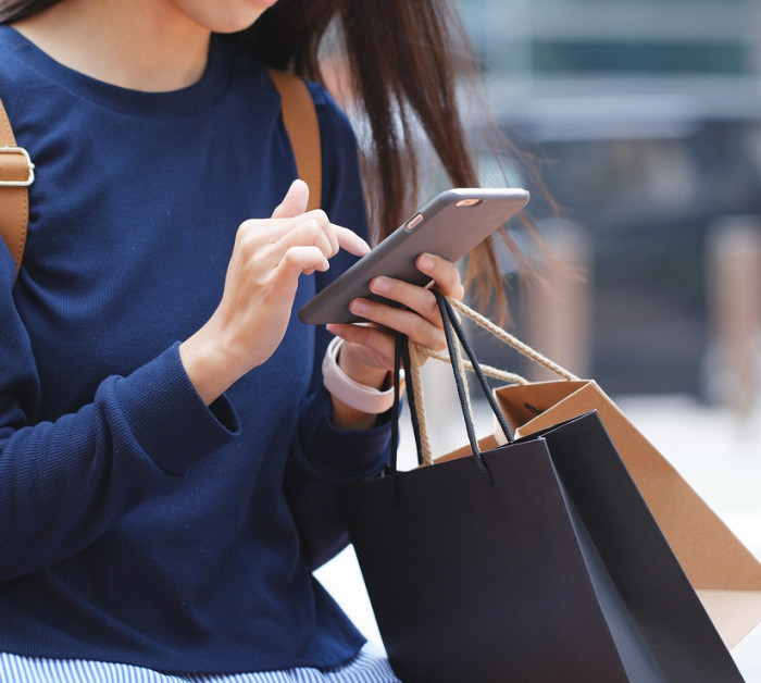 woman look mobile phone holding shopping