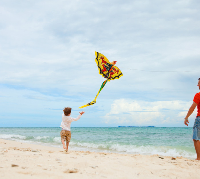 young father his son running kite