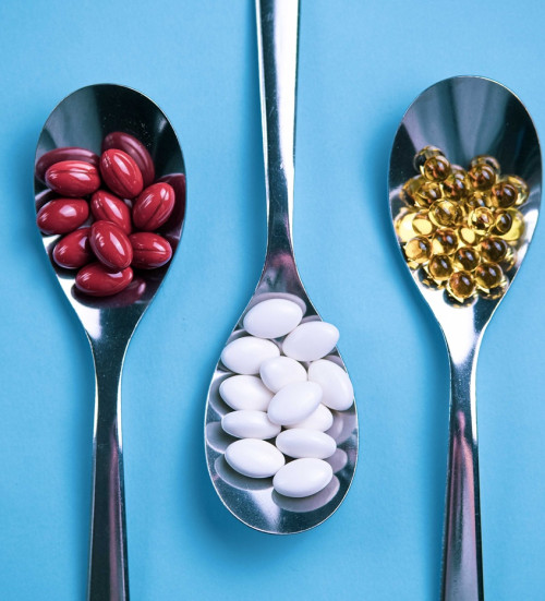 spoons pills on light blue background