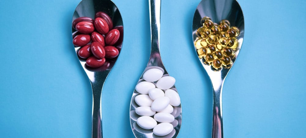 spoons pills on light blue background