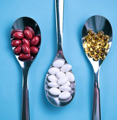 spoons pills on light blue background