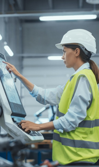 female machinery technician using laptop computer