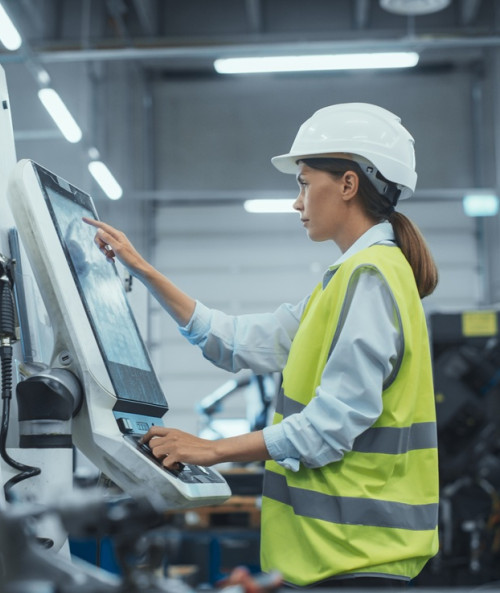 female machinery technician using laptop computer
