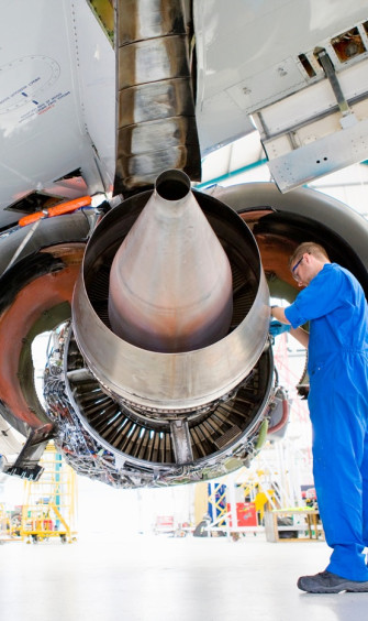 wide shot engineer uniform working under plane