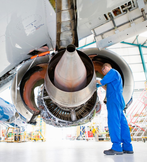 wide shot engineer uniform working under plane