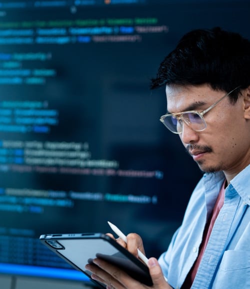 asian male software developer works multiple computers