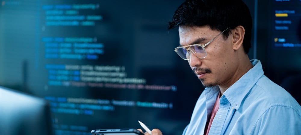 asian male software developer works multiple computers