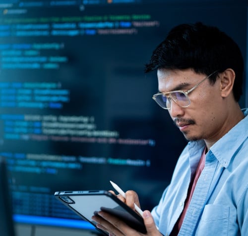 asian male software developer works multiple computers